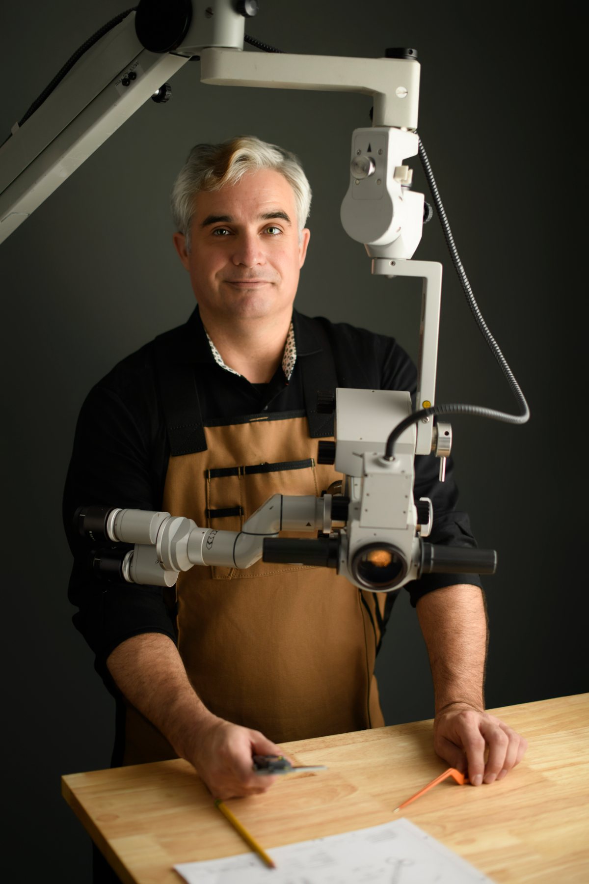 Alexander C. Ebner at his bench under a surgical microscope