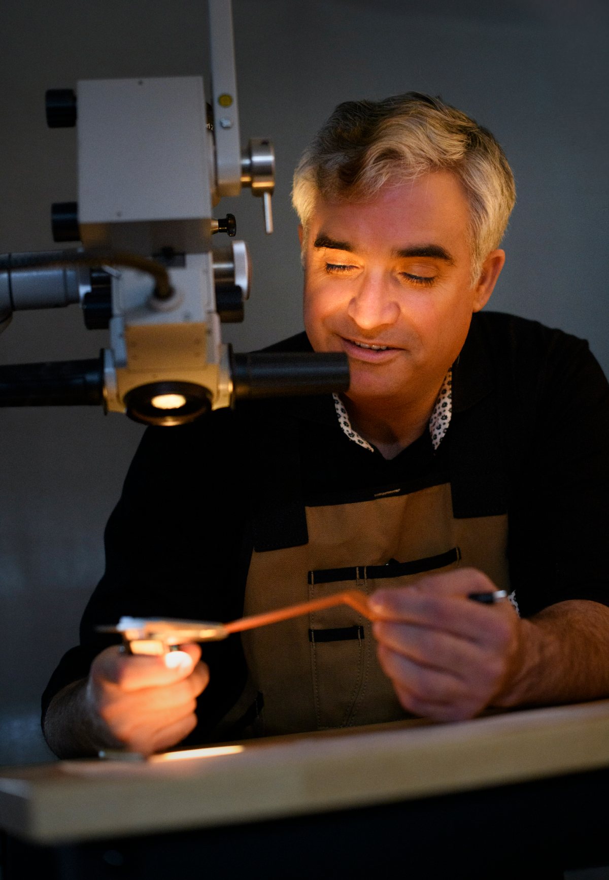 Alexander C. Ebner examining an instrument under a surgical microscope